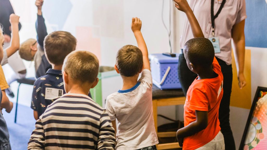 Students raising hand in classroom