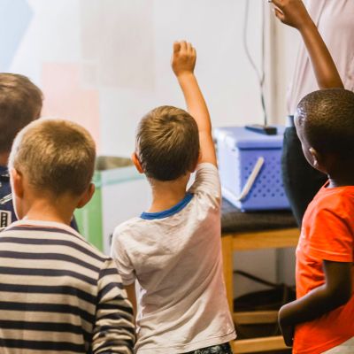 Students raising hand in classroom