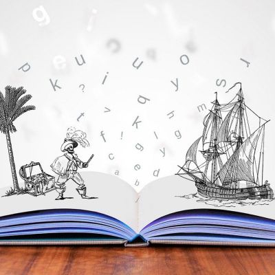 book open on a table with a sceen of a pirate and ship popping out