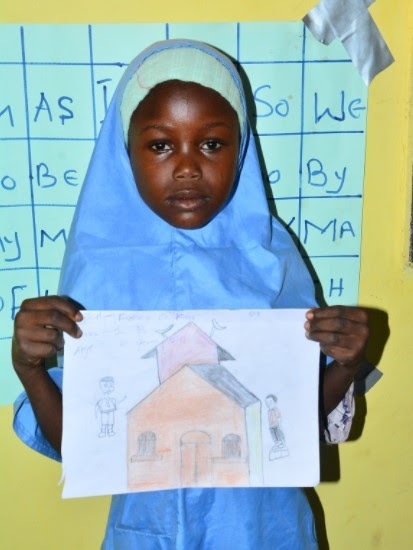 Global connection - student with drawing student holding up a drawing of a house