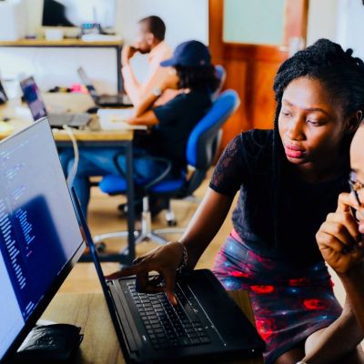 teacher helping student on a computer