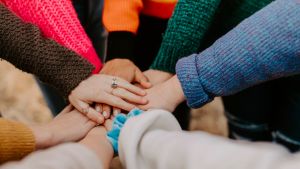 hands on top of each other together in a circle