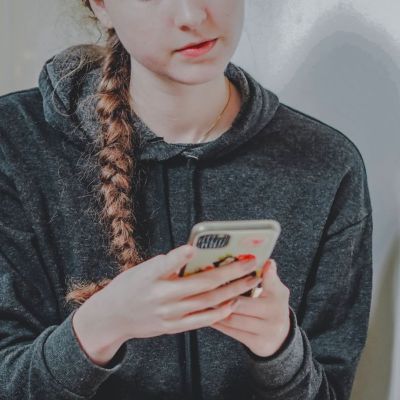 teenager holding and using a phone
