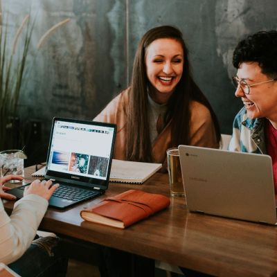 group of women discussing over laptops