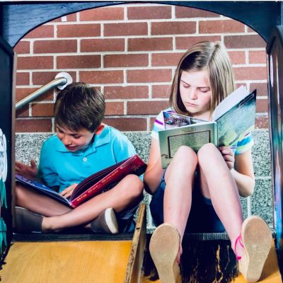 children reading on a slide
