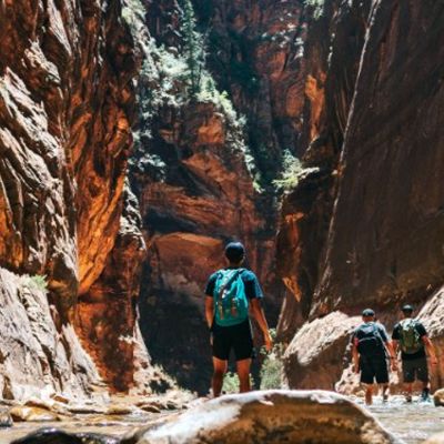 stream running through a canyon with people