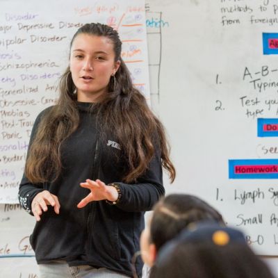 student talking at the front of the classroom