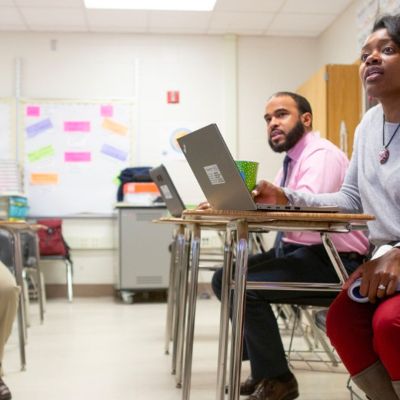 3 teachers sitting at desks