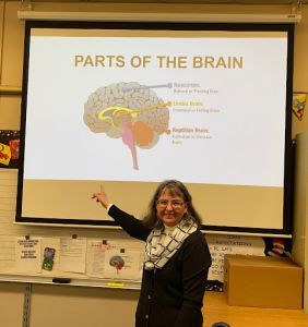 a teacher pointing to a presentation