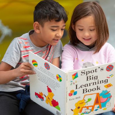young children reading a book together