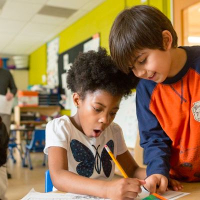 two students excitedly working on a worksheet