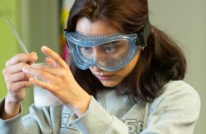 Student mixing a mixture in a beaker