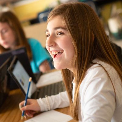 young student smiling while doing work