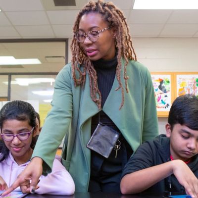 teacher helping students on their tablets