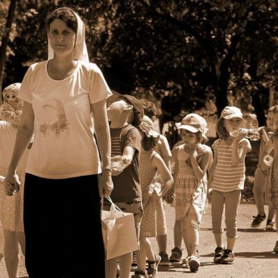teacher walking in front of students in a line outside