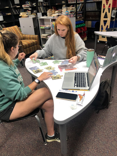 Two more teachers working on puzzle pieces.