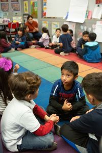 Children sitting together on the floor in a classroom