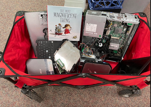 The Most Magnificent Thing with computer parts Book inside a wagon with parts.