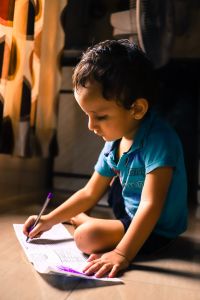 Child writing on paper.