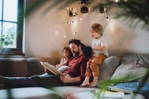 Parent reading a book to children.