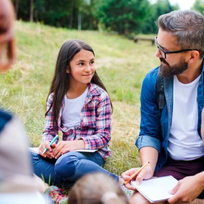 Teacher with students outdoors.
