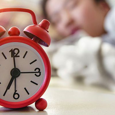 Student sleeping with an alarm clock.