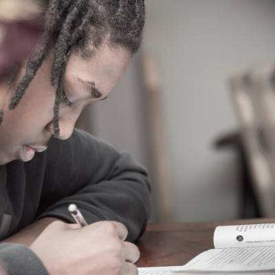 Student writing on paper.