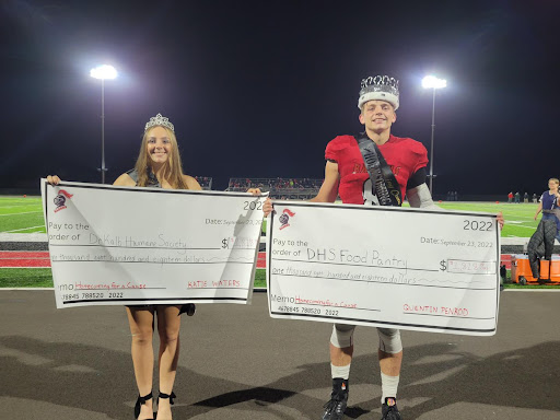 Charity during Homecoming Students holding large checks for charity.