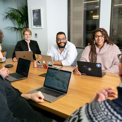 People sitting at a table with their laptops.