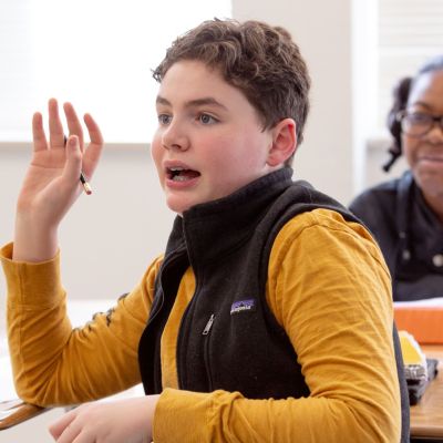 Student raising hand to ask a question.