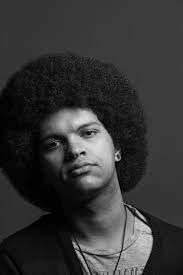 Man with an afro posing for a picture.