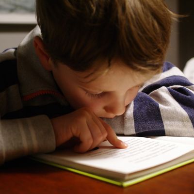 Small boy reading a book.