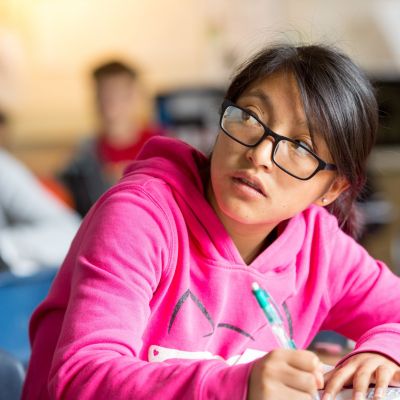 A student journals her response to a writing prompt in a tenth-grade English class.