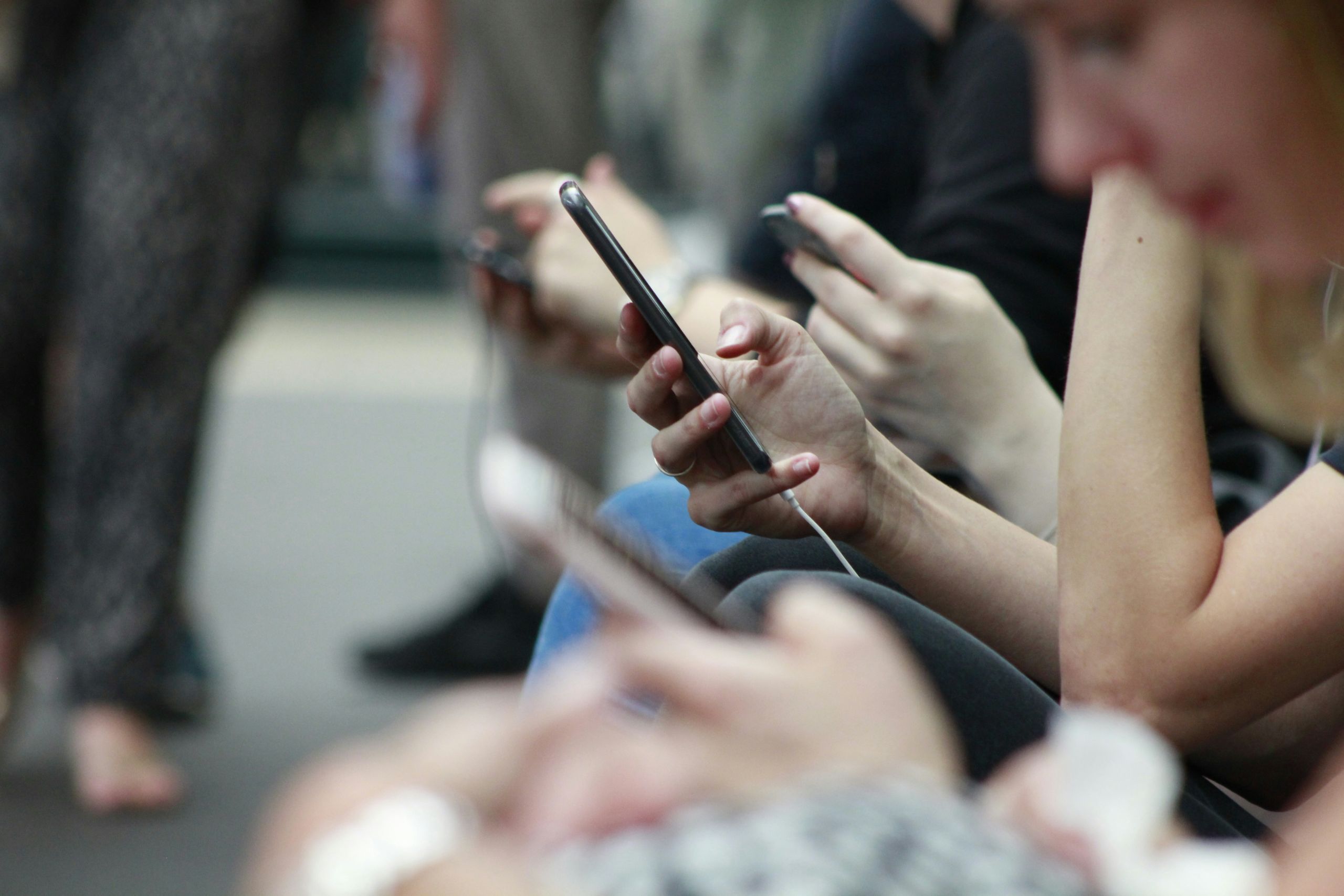 Person holding a black cell phone in their hand.