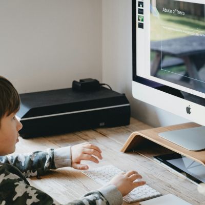 Boy sitting at a computer and doing some design work for a project.