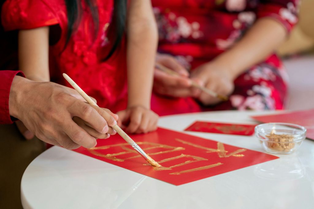 Children and an adult practicing writing.