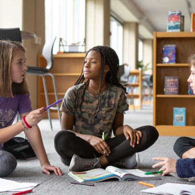 Seventh-graders work together on homework in their school library.