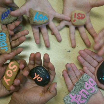 Spanish words painted on small stones.