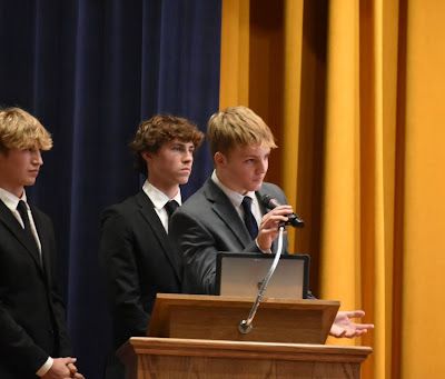Three Students at a podium