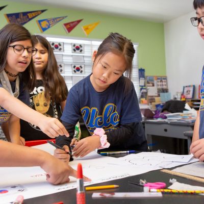 Students in a combined fourth- and fifth-grade class work together on a poster about the Lunar New Year.