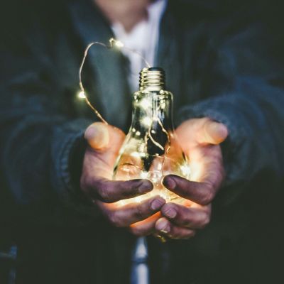 Person holding a lightbulb.