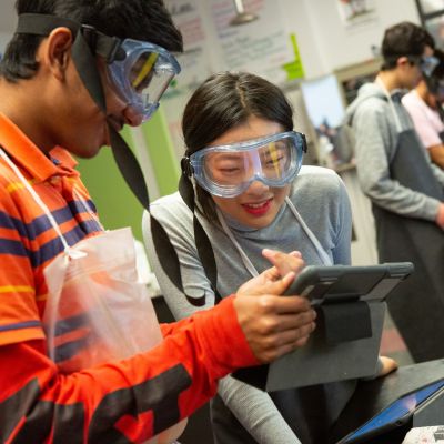 High school students read their lab directions on a computer tablet during AP chemistry class.
