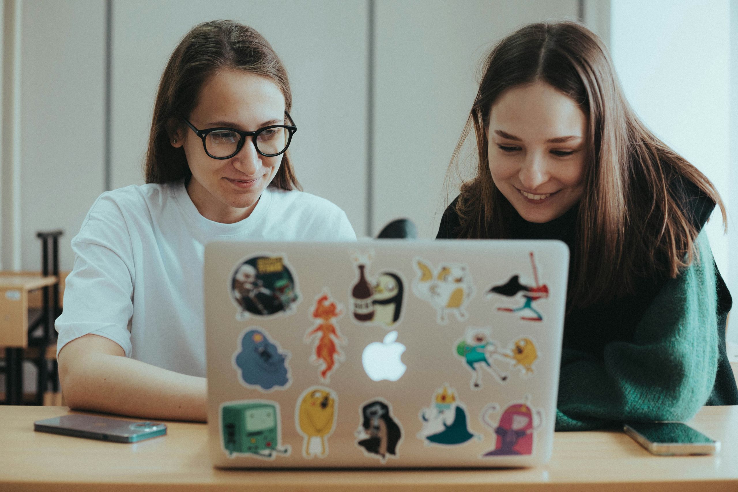 Two people working at a laptop together.