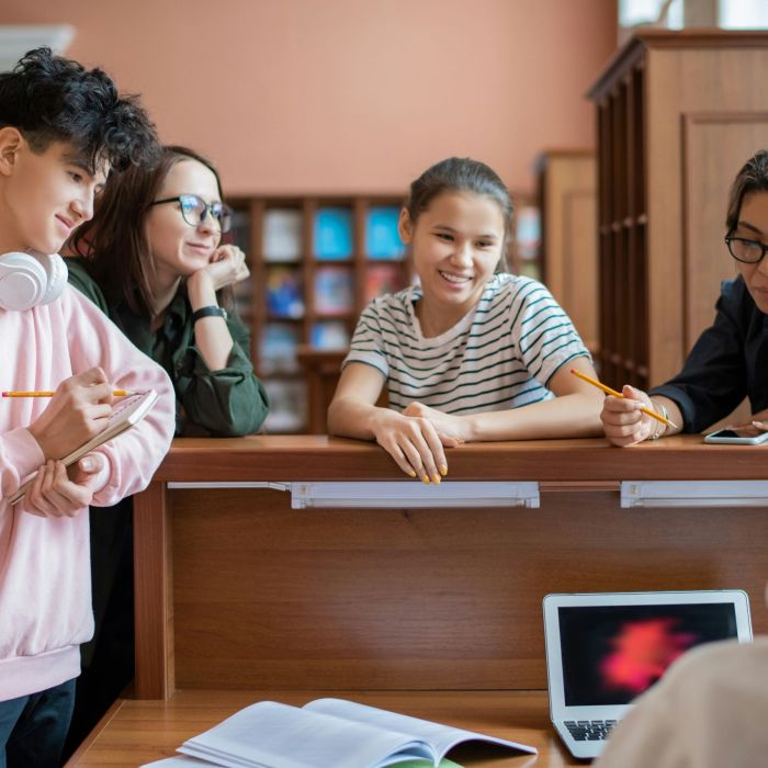 Students asking a question in a library.